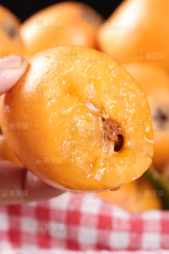 手里拿着新鲜枇杷