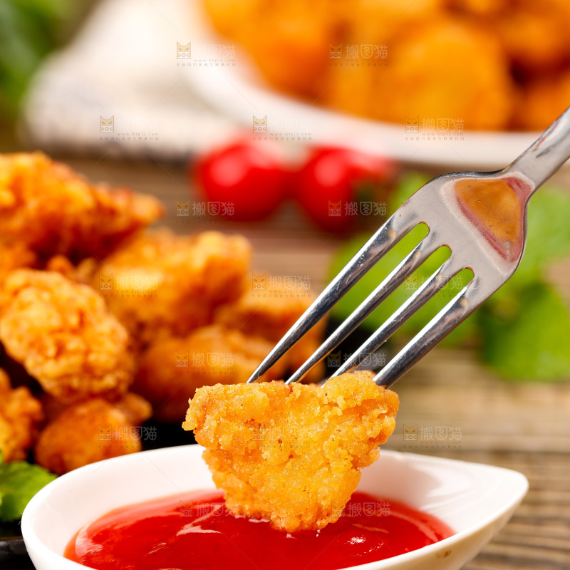 叉子上插着沾番茄汁的鸡米花
