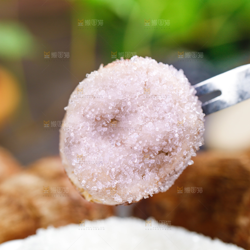 叉子上插着沾糖的小芋头