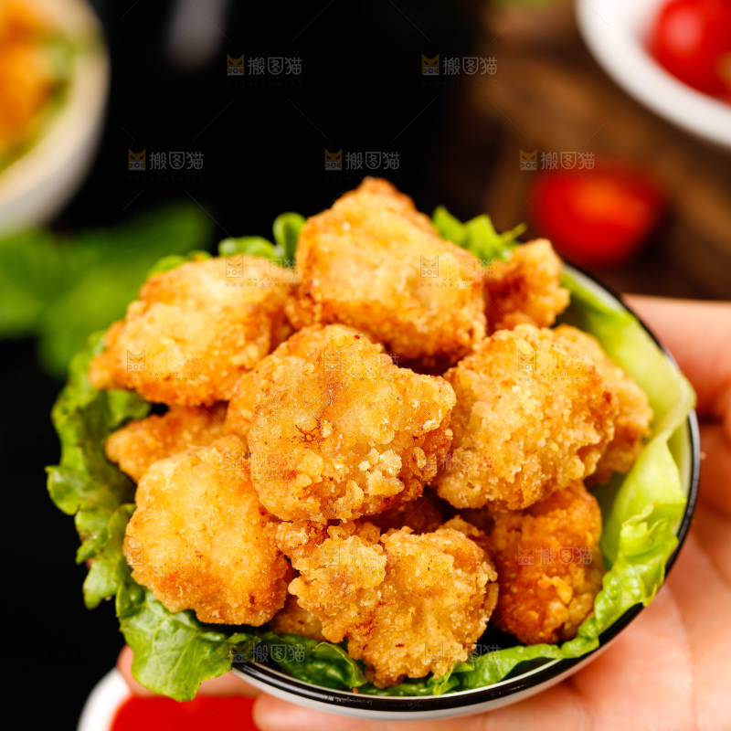 手上端着一碟油炸鸡米花