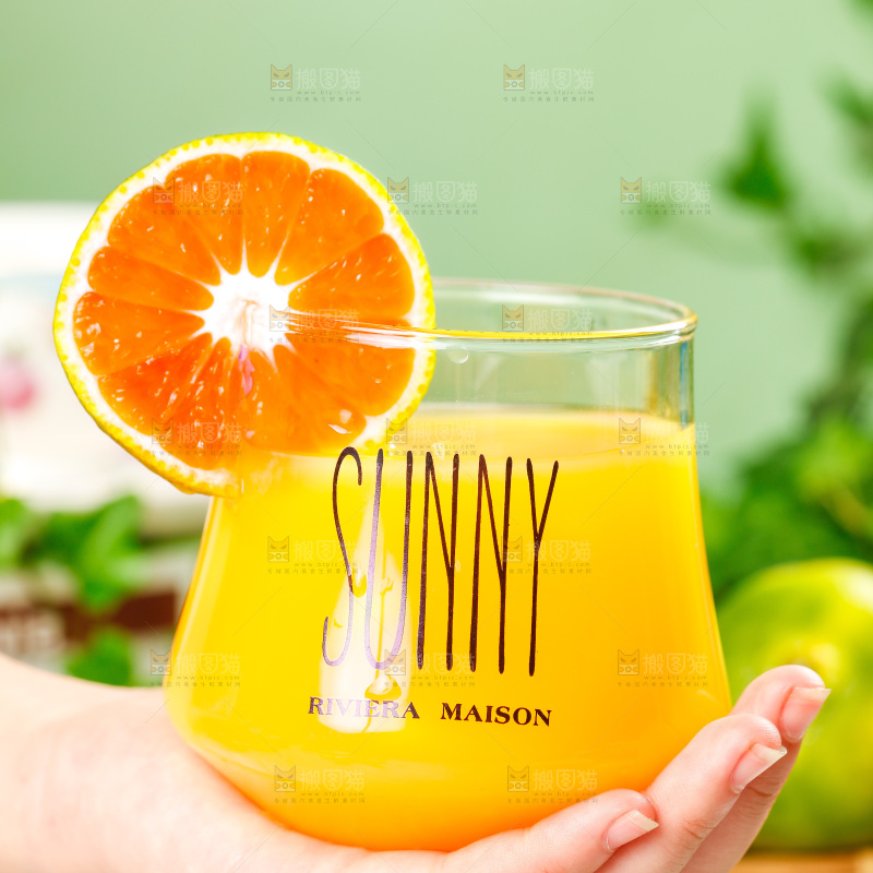 手上端着一杯橘子汁