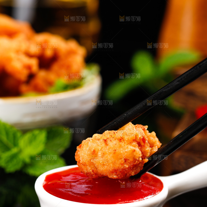 筷子上夹着沾番茄酱的黄金鸡米花