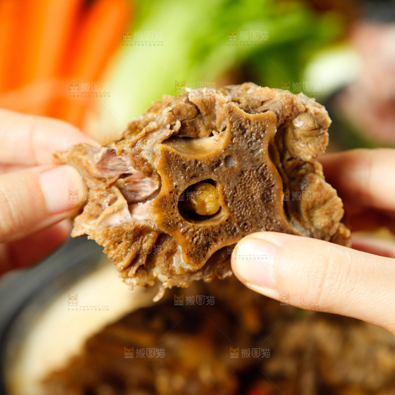 手里拿着煮熟的羊蝎子