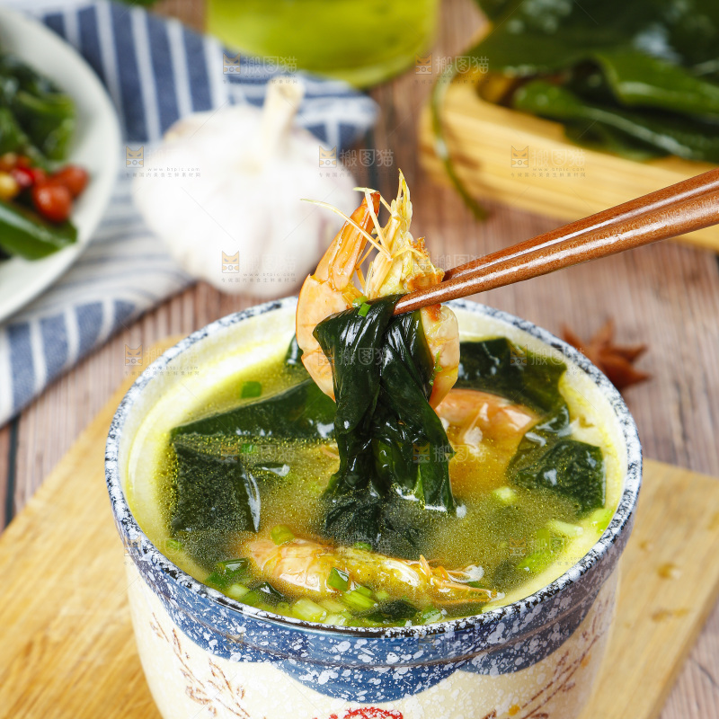 木底上放着一杯裙带菜大虾汤