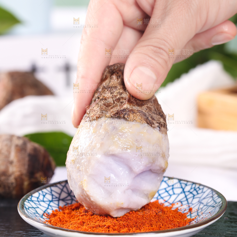手拿蘸辣椒的香芋