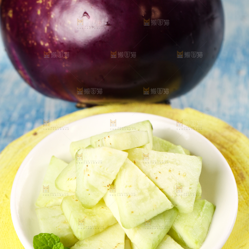 木板上放着一碟削皮的茄子