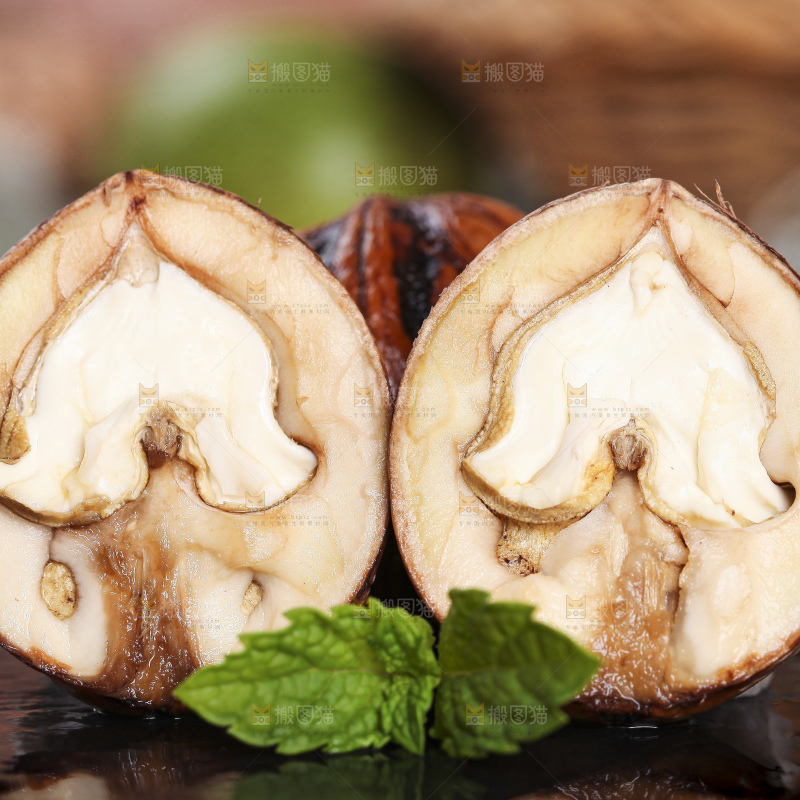 黑石板上放着切开的去皮湿核桃