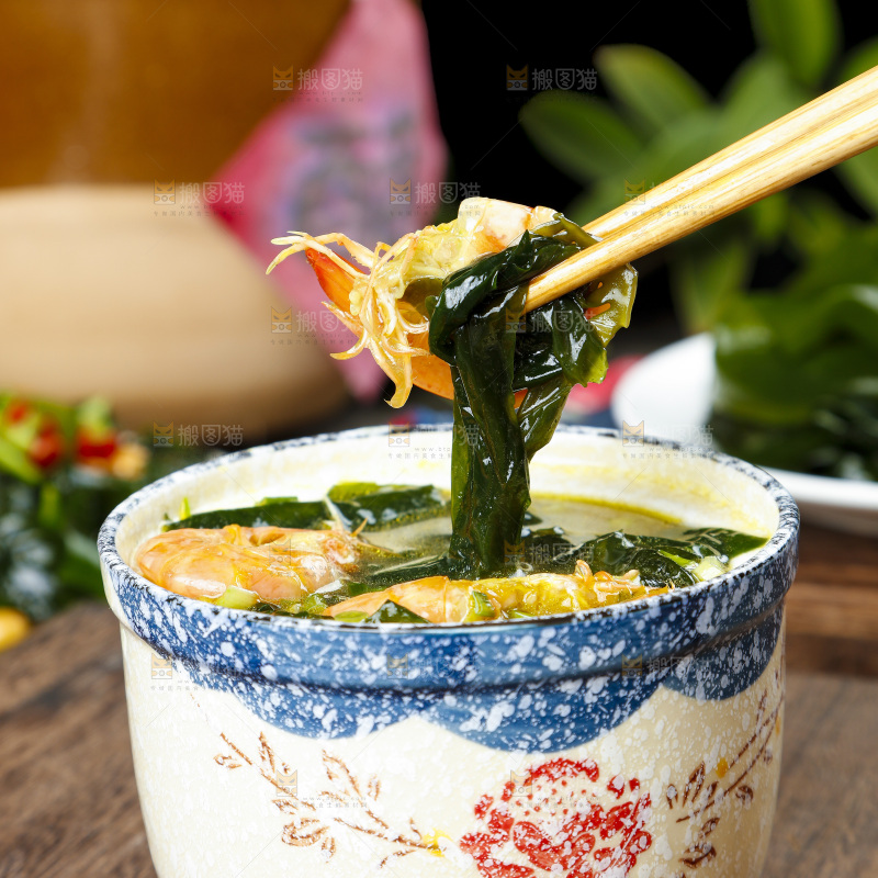 木底上放着一杯裙带菜大虾汤