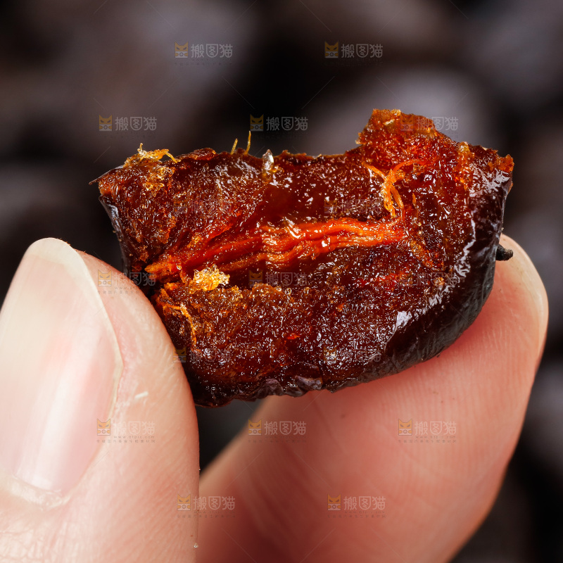 手拿掰开的黑枣