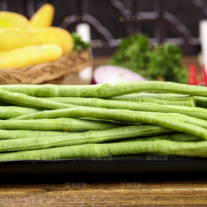 木板上放着一盘新鲜豆角