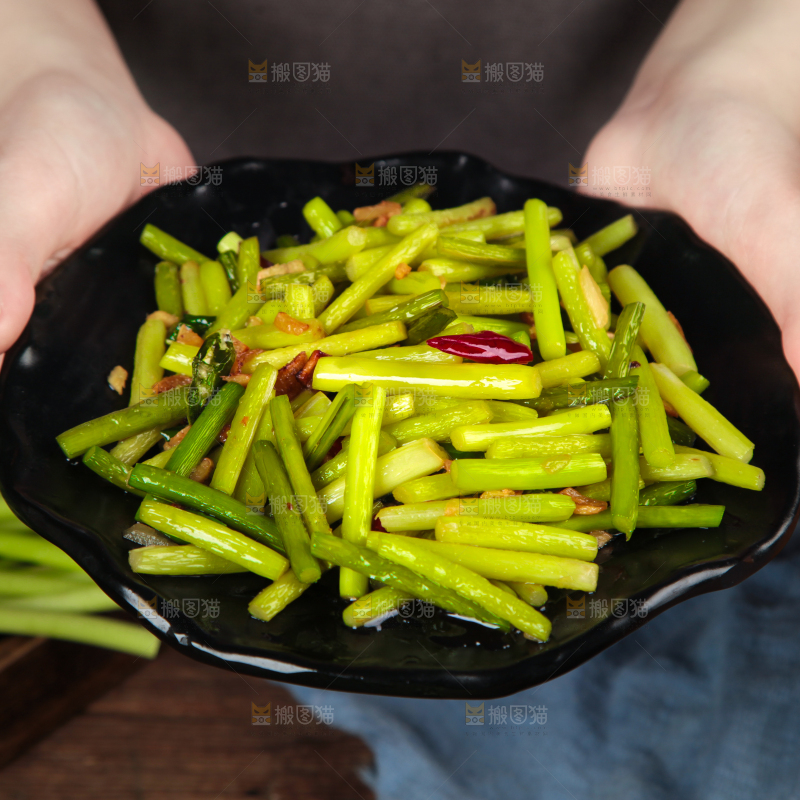 手拿一盘清炒蒜苔