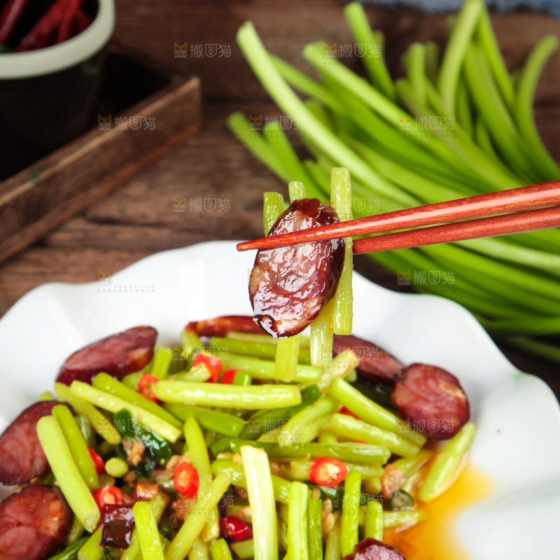 筷子夹着腊肠炒蒜苔