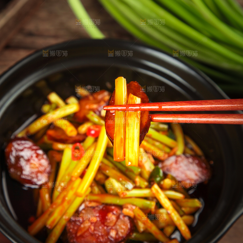筷子夹着蒜苔炒腊肠
