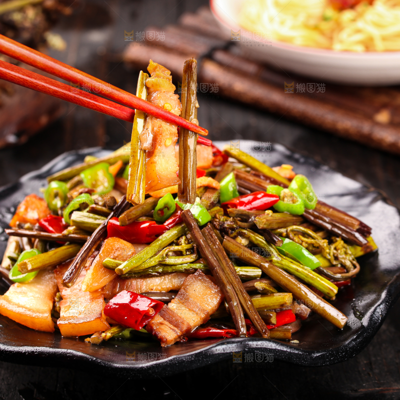 筷子夹着蕨菜炒肉