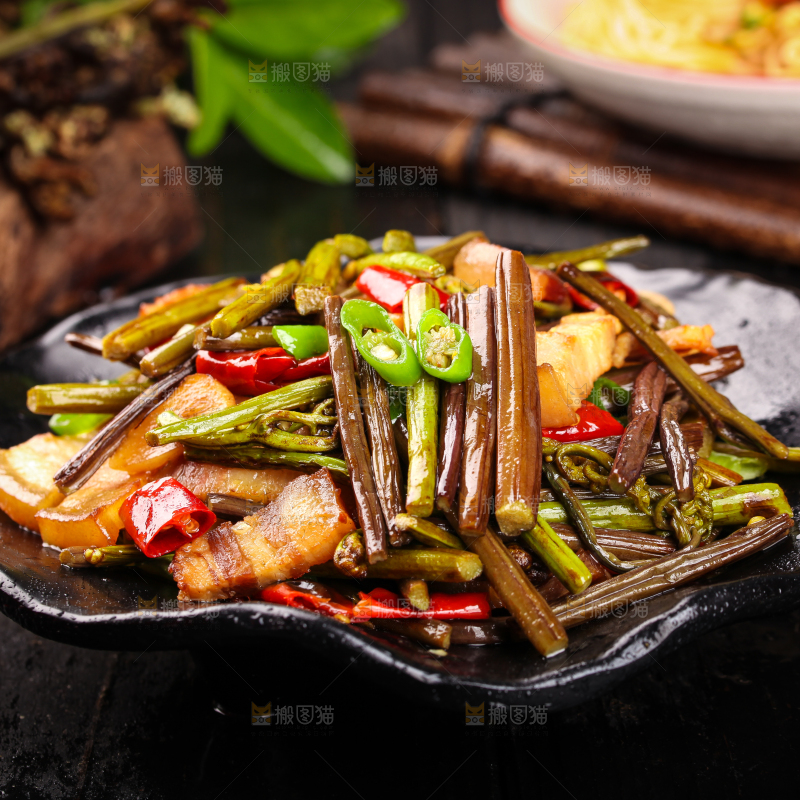 黑底上放着一盘蕨菜炒肉