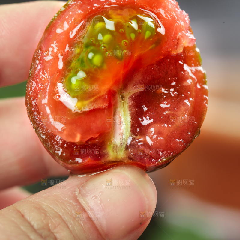 手拿掰开的樱桃小番茄