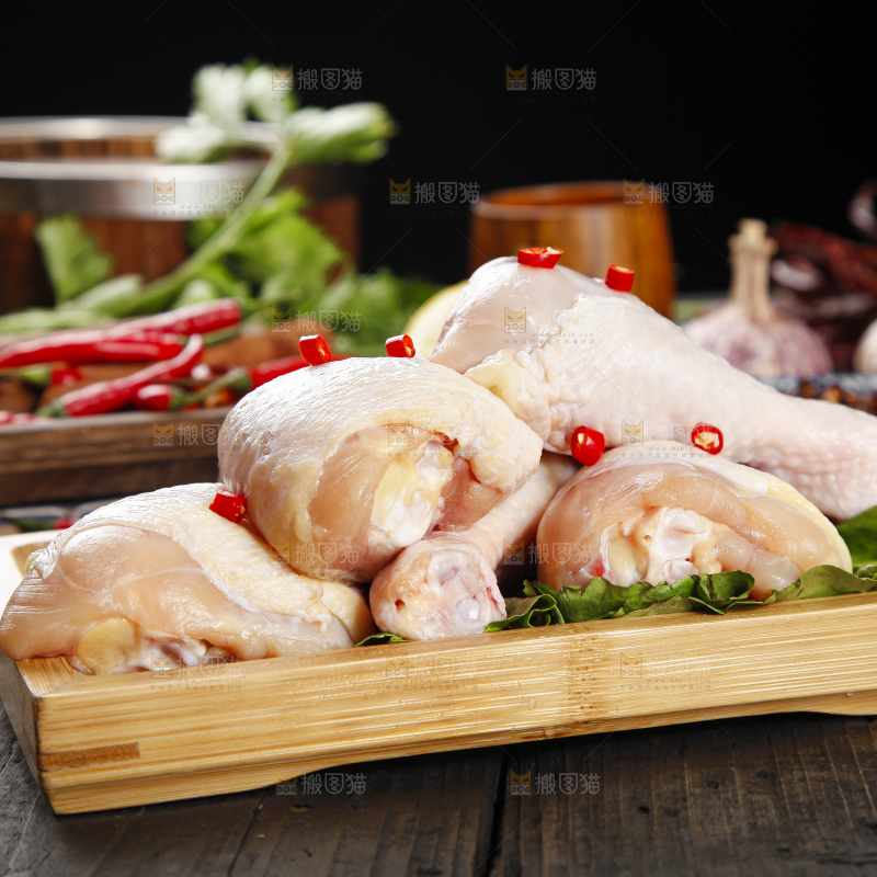 木板上放着一盘新鲜鸡腿