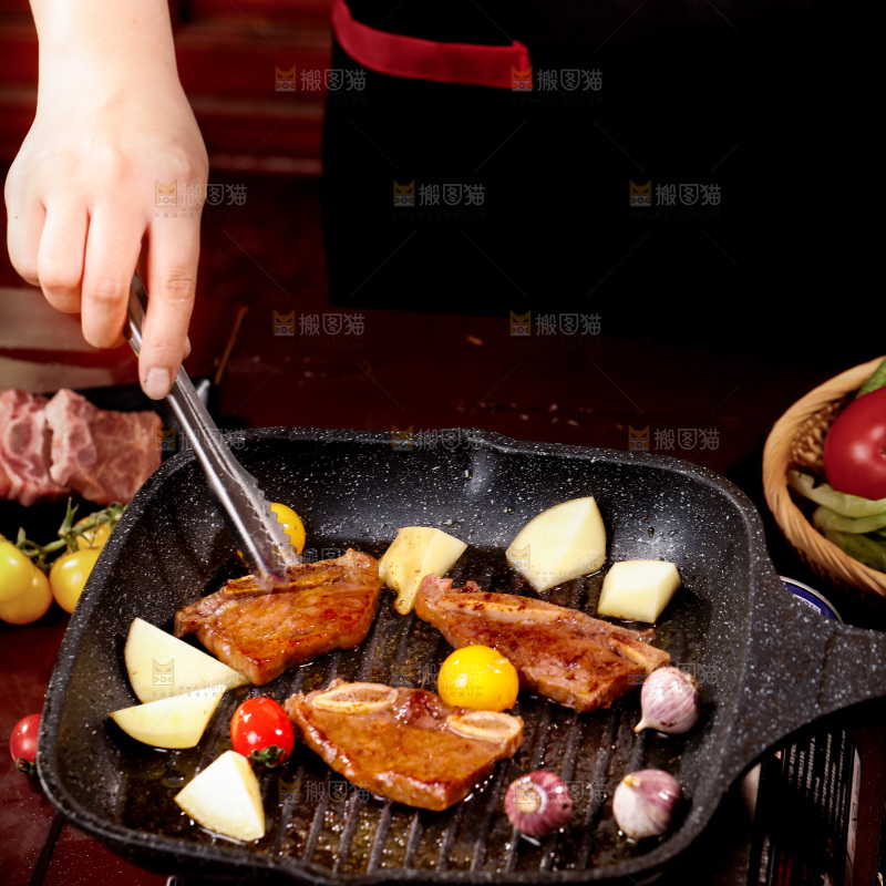 锅里放着正在煎的牛仔骨