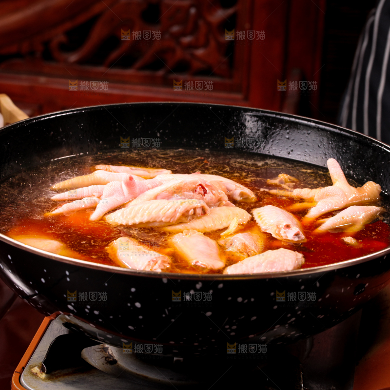 锅里装着正在卤鸡爪和鸡中翅