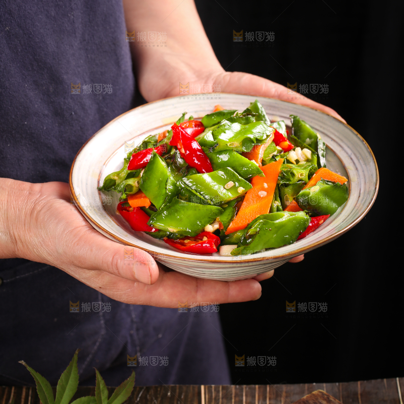手里拿着一盘炒四角豆