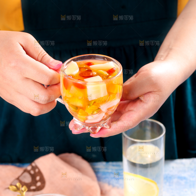 手里拿着一杯水果凉粉