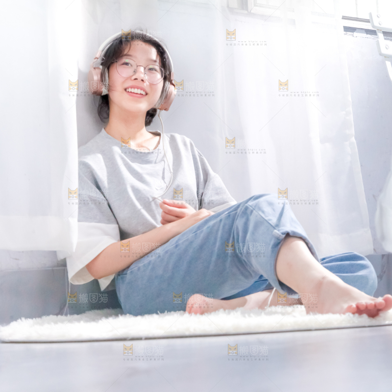 毛毯上坐着一位带耳机的女孩