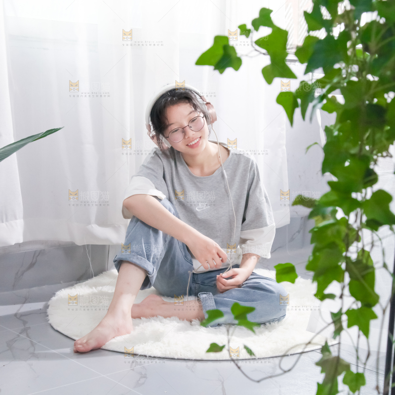 毛毯上坐着一位带耳机的女孩