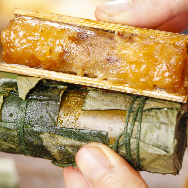 手里拿着竹筒糯米饭
