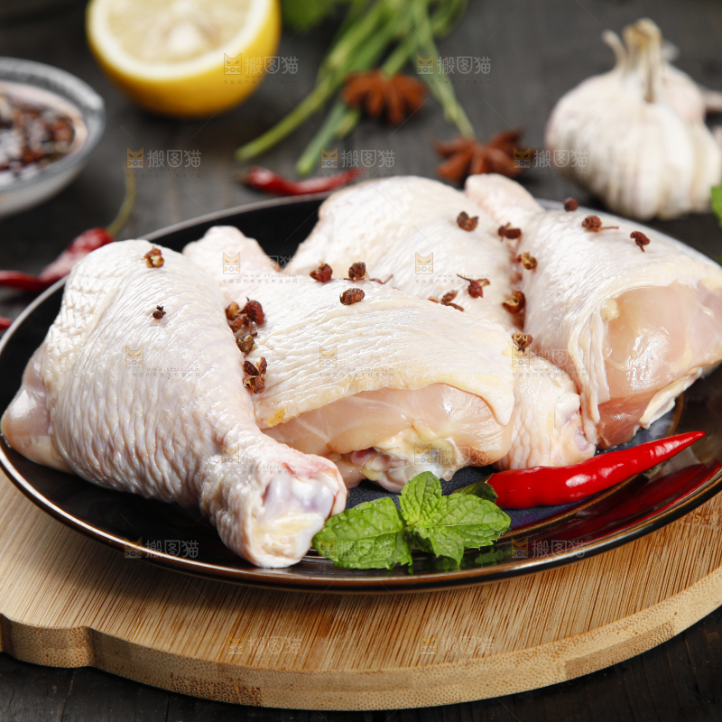 木板上放着一盘新鲜鸡腿