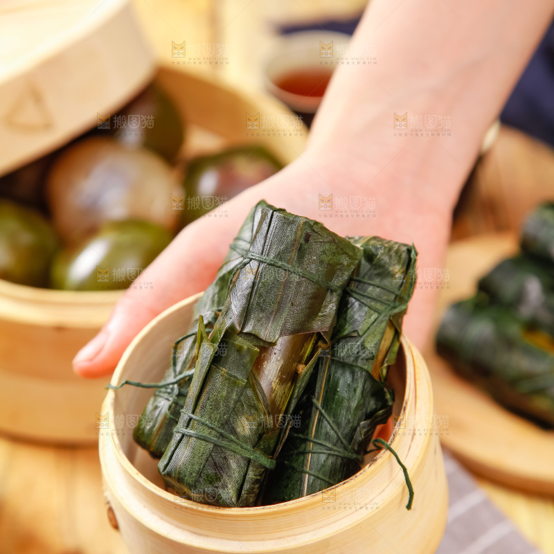 手里拿着竹筒肉粽