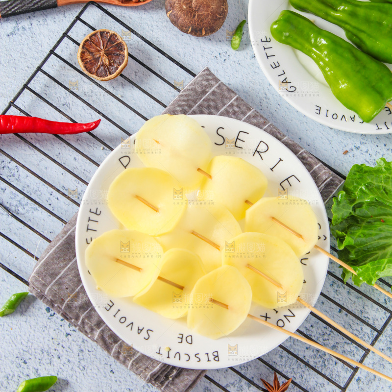 一盘土豆串放在浅底上