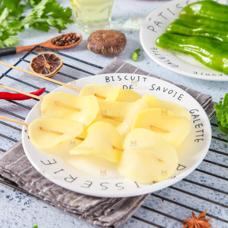 一盘土豆串放在浅底上