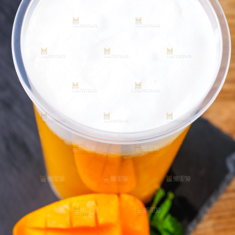 黑石板上放着一杯芒果果汁