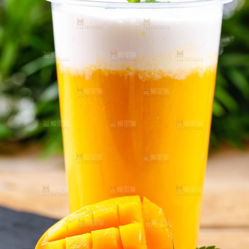 黑石板上放着一杯芒果果汁