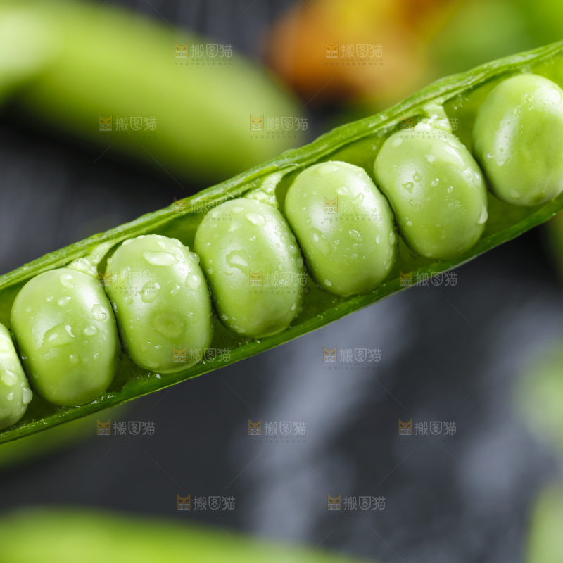 黑石板上堆放着甜豌豆