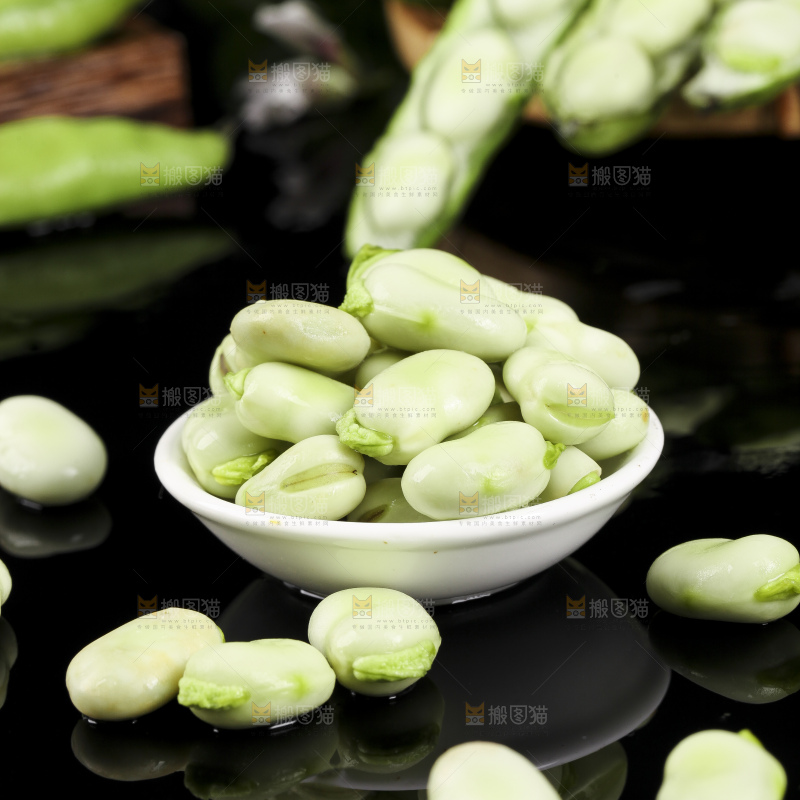 一碗新鲜蚕豆粒放在黑底上