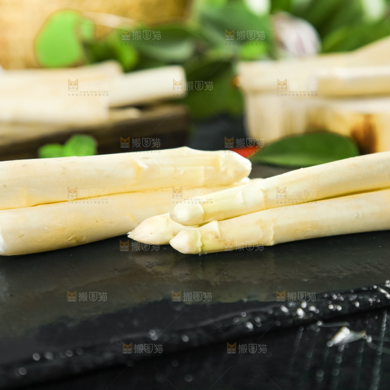 黑石板上放着切开的白芦笋