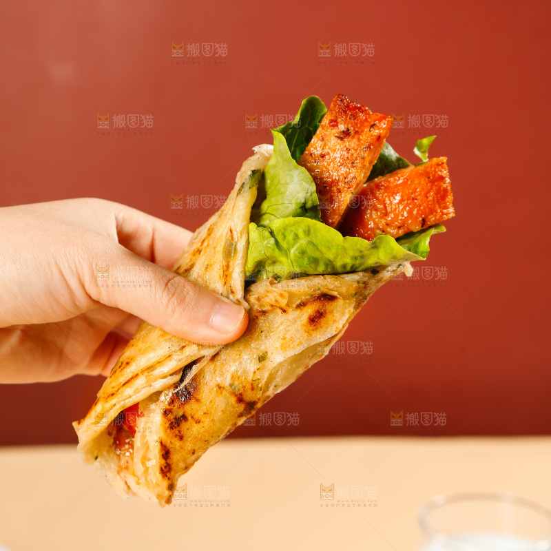 手上拿着一个卷饼