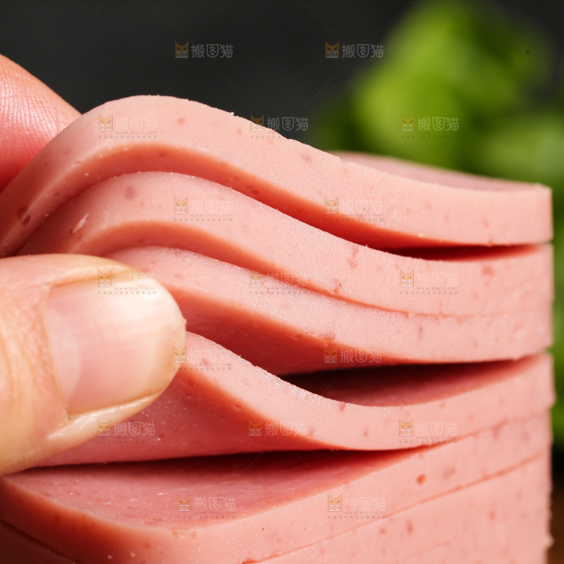 手里拿着切片的午餐肉