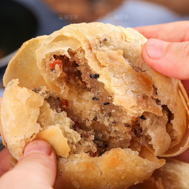 手拿着掰开的酥皮月饼
