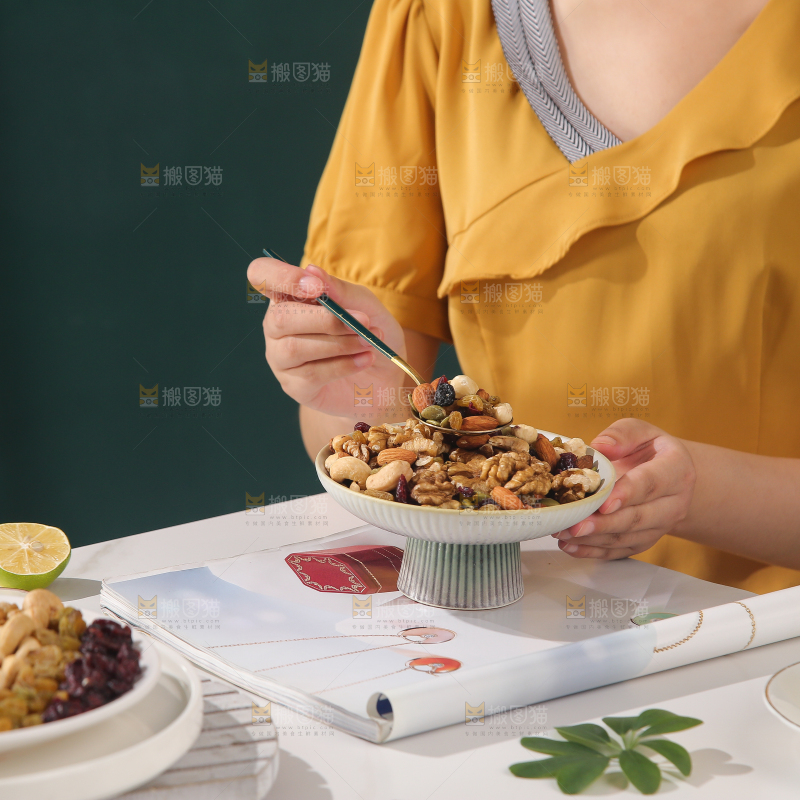 女孩端着一盘坚果组合
