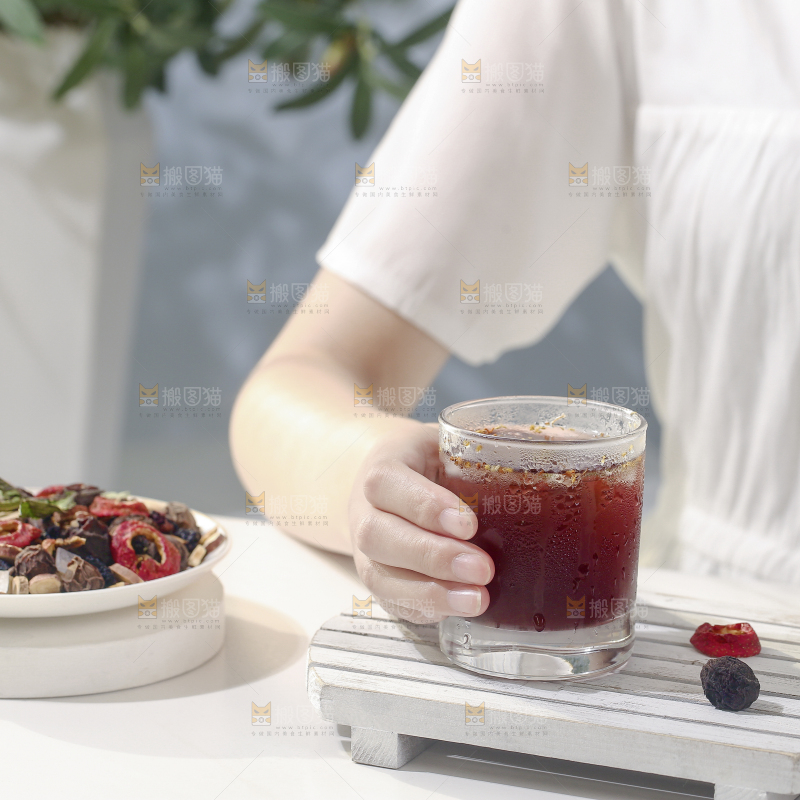 手上拿着一杯酸梅汤