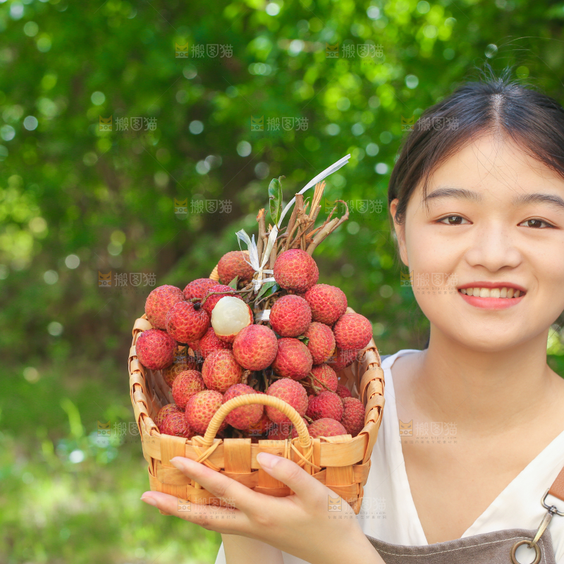 女人手上拿着一筐无核荔枝