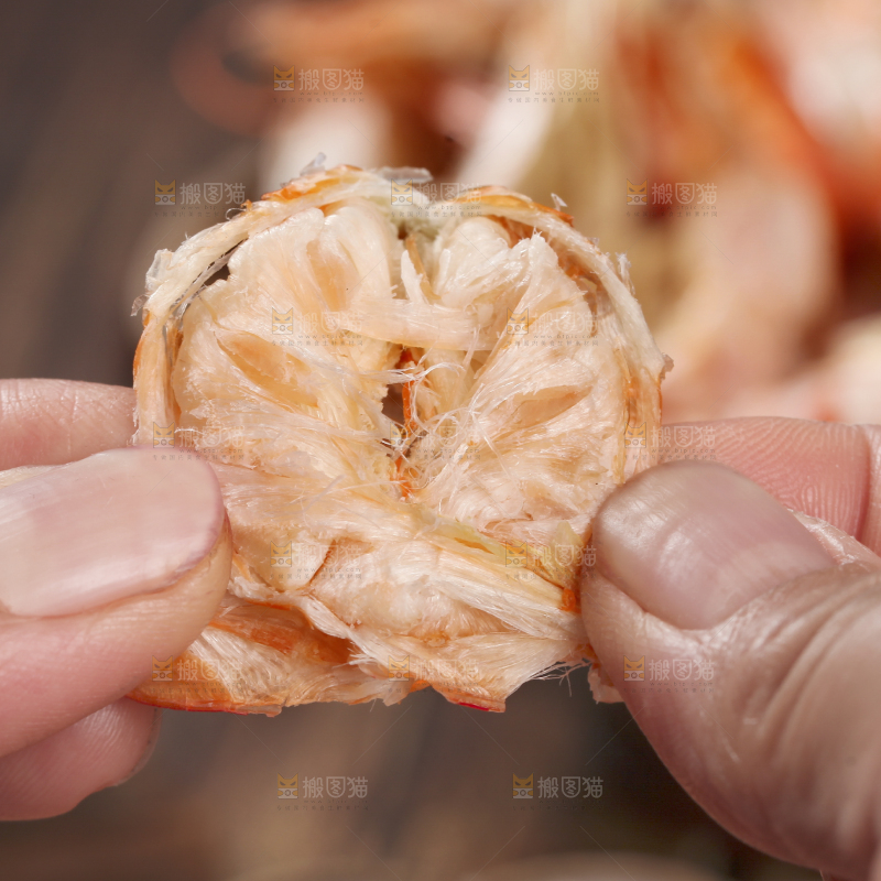 手拿着烤虾干