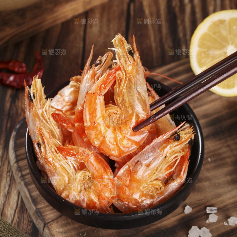 筷子上夹着碳烤虾