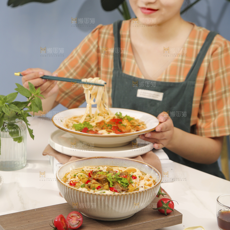 女孩手上端着一碗牛腩拉面