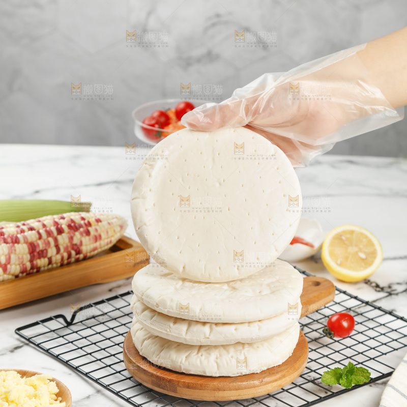 手上拿着披萨胚