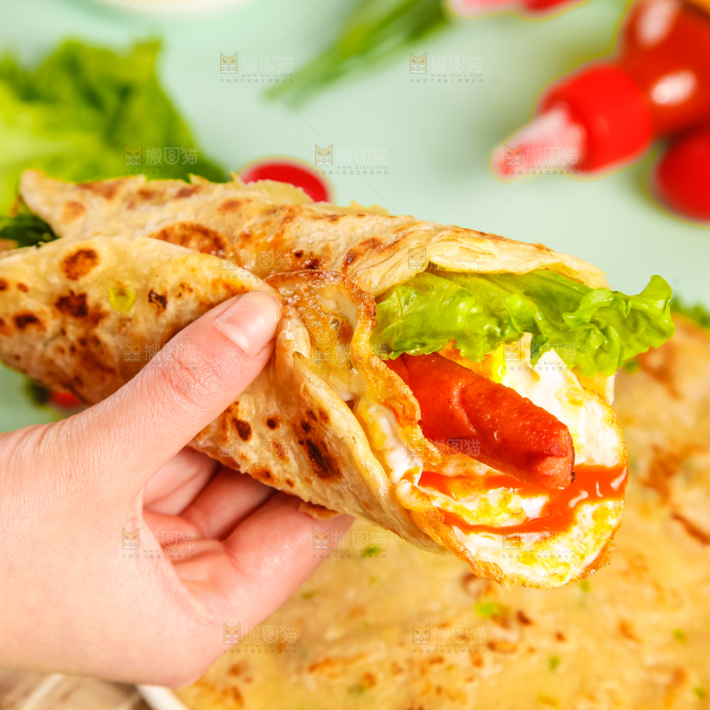 手拿着手抓饼卷
