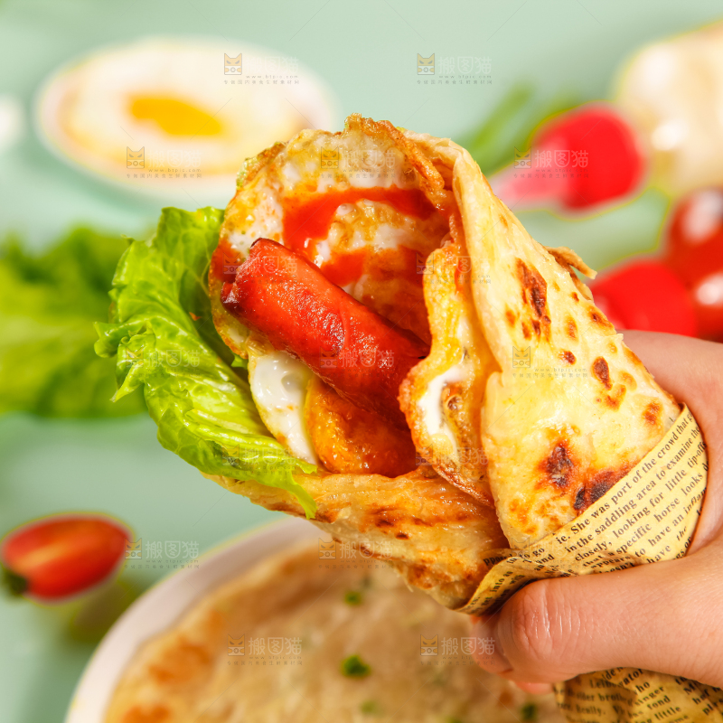 手拿着手抓饼卷