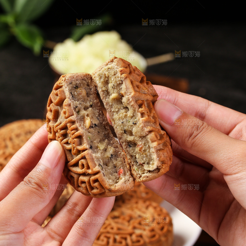 手拿着掰开的荞麦五仁月饼